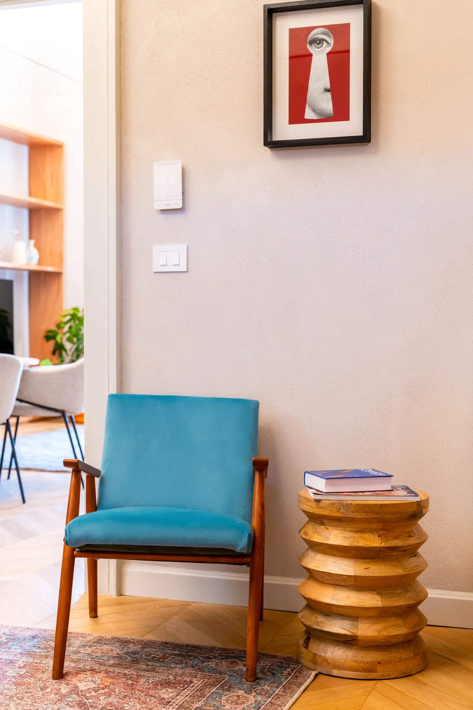 Poltroncina azzurra con tavolino in legno tornito e libri