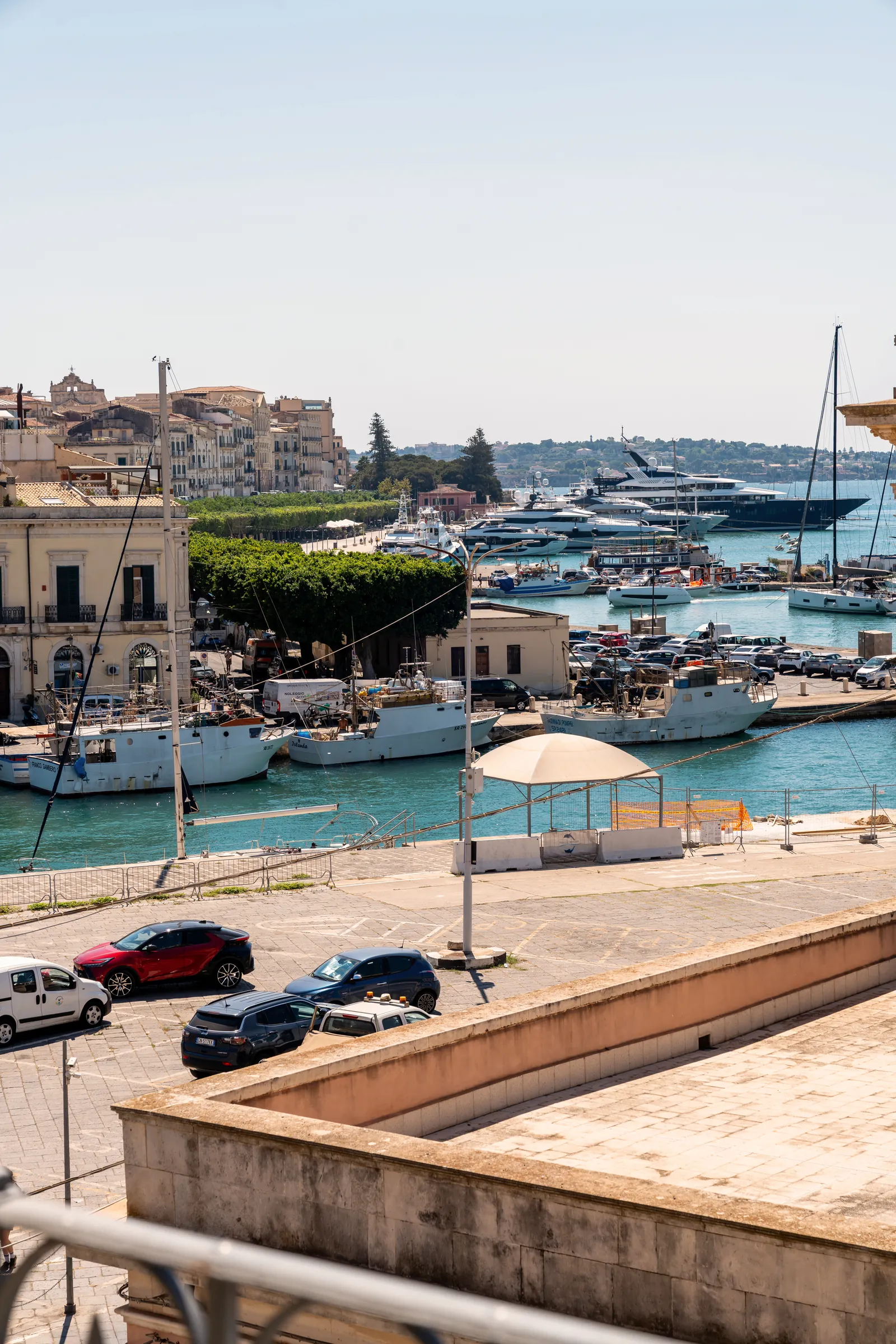 Vista dal balcone sul porto con barche e yacht e Ortigia sullo sfondo